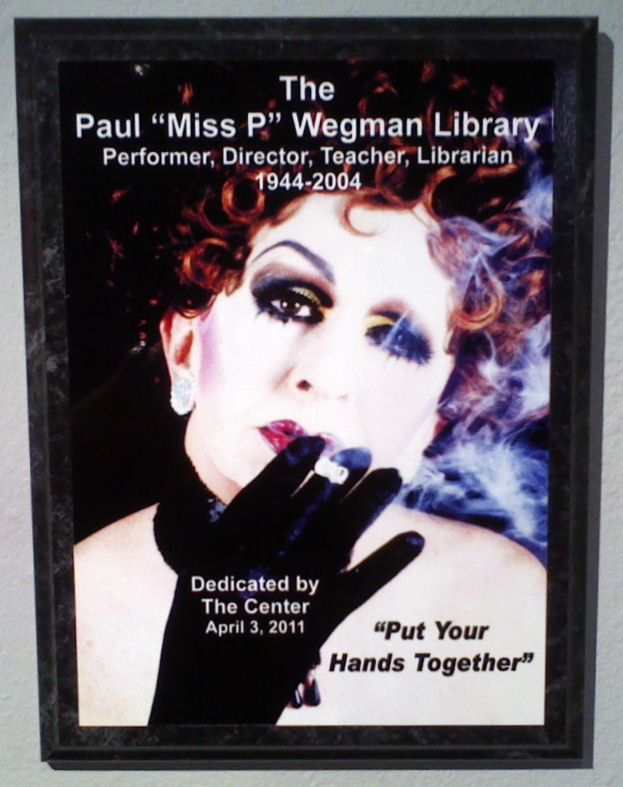 Framed image in dedication to Paul Wegman- Miss P which states:
The Paul "Miss P" Wegman Library
Performer, Director, Teacher, Librarian
1944-2004
Dedicated by the Center April 3, 2011
"Put Your Hands Together".

Image of Miss P smoking was taken by Loc Robertson. 

For all other purposes please email: floridalgbtqmuseum@gmail.com